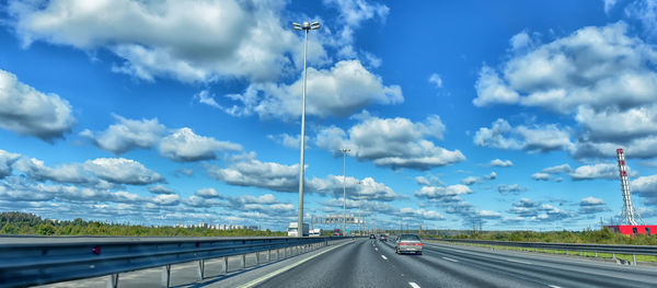 Vehicles on highway against sky
