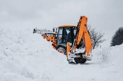 Tractor bucket unfolds snow outside