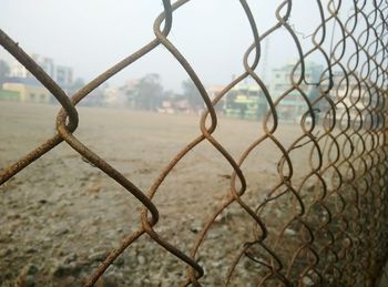 Close-up of chainlink fence against sky