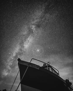 Low angle view of boat against star field sky at night