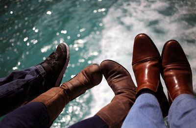 Low section of family wearing shoes over sea