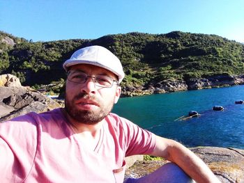 Portrait of man against sea and mountain