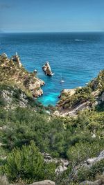 High angle view of rock formation by sea against sky