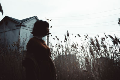 Woman standing on field against sky