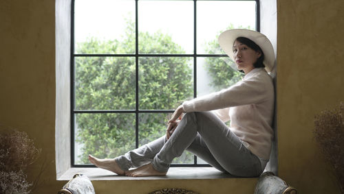 Asian woman sitting on europe style window shield during trip vacation