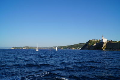 Scenic view of sea against clear blue sky