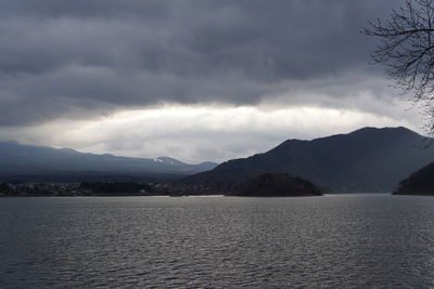 Scenic view of lake by mountains against sky