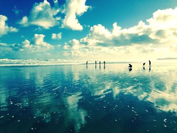 People on beach against sky