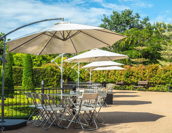 Empty chairs and table against trees