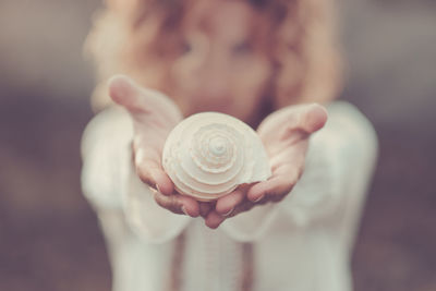 Close-up of woman holding sea shell