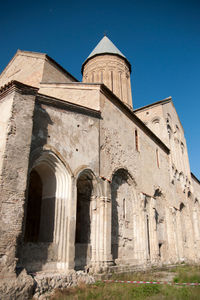 Low angle view of old building against clear blue sky