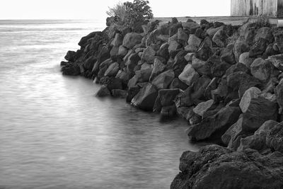 Rocks on sea shore against sky