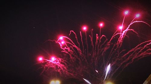 Low angle view of firework display at night