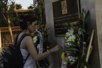 Woman standing by potted plant