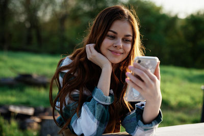 Portrait of young woman using mobile phone