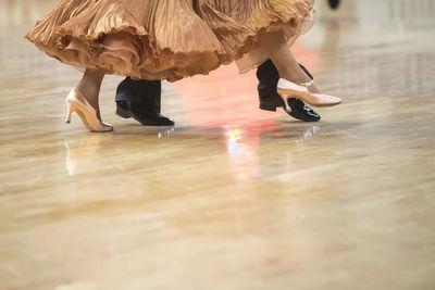 Low section of women dancing on hardwood floor