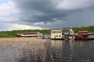 Building by lake against sky