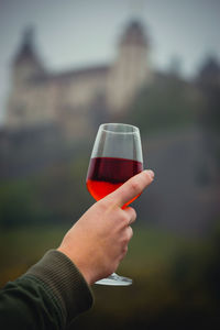 Eine frauenhand hält ein weiglas mit wein in der hand. 