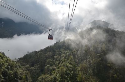 Low angle view of overhead cable car against sky