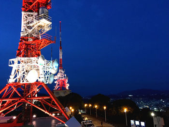 Low angle view of illuminated radio tower against sky at night