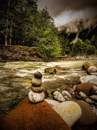 Scenic view of river against cloudy sky