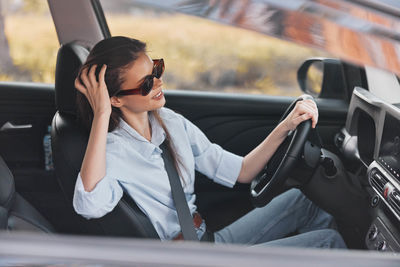 Young woman sitting in car