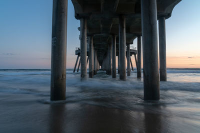 Pier on sea against sky during sunset