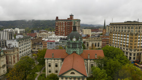 Buildings in city against cloudy sky