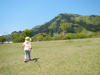 Full length of girl standing on grassy field