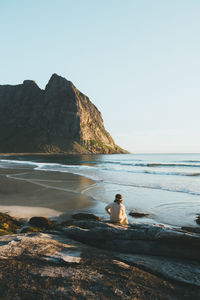 Man looking at sea against clear sky