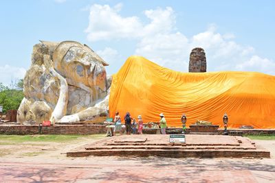 People by reclining buddha statue at wat phra ram