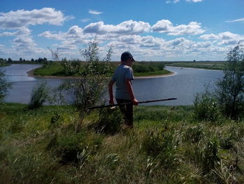 Rear view of man looking at lake