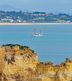 Sailboat anchored in quarantine on sea against sky