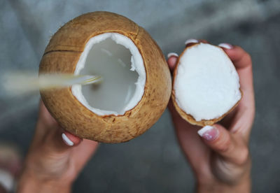 Close-up of hands holding coconut drink