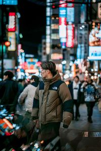 People standing on city street at night