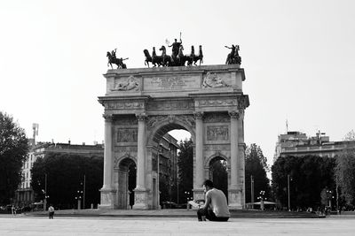 Statue of people in front of gate