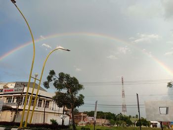 Low angle view of rainbow over buildings in city