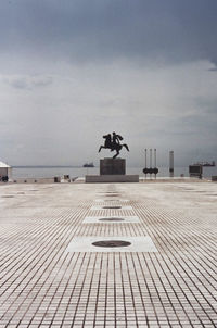 Statue by sea against sky in city