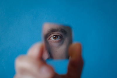 Portrait of human hand holding blue eyes
