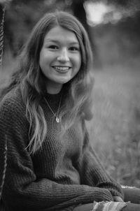 Portrait of smiling young woman sitting outdoors