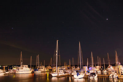 Boats moored in harbor at night