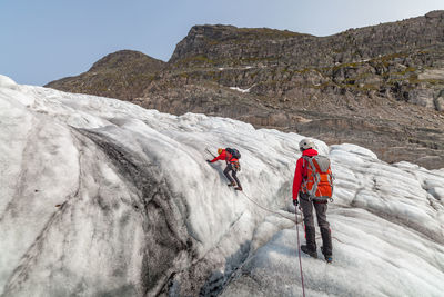 People hiking on snow covered mountains at jostedalsbreen