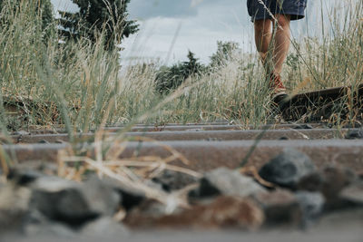 Low section of person walking on abandoned railroad track