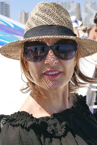 Portrait of smiling woman wearing sunglasses and hat in city during sunny day