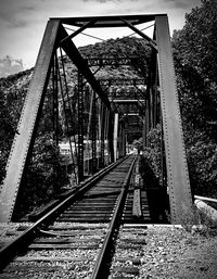 Railroad tracks in bridge against sky