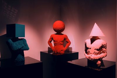 Close-up of toys on table against illuminated wall