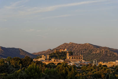 Town by mountains against sky