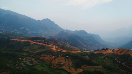 Scenic view of agricultural landscape against sky at sunset