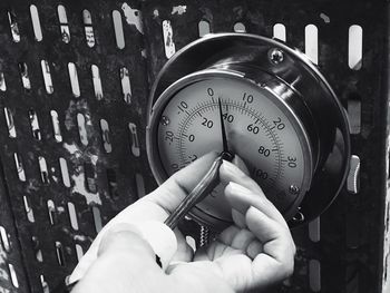 Close-up of hands touching gauge