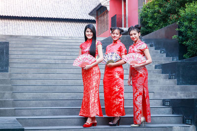 Young woman with red umbrella in traditional building